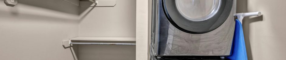 A stacked washer and dryer in a laundry closet