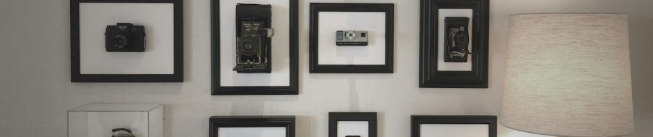 Black-framed photographs hung in a grid above a table lamp
