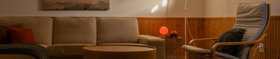A cozy living room with a sofa, an armchair and a floor lamp